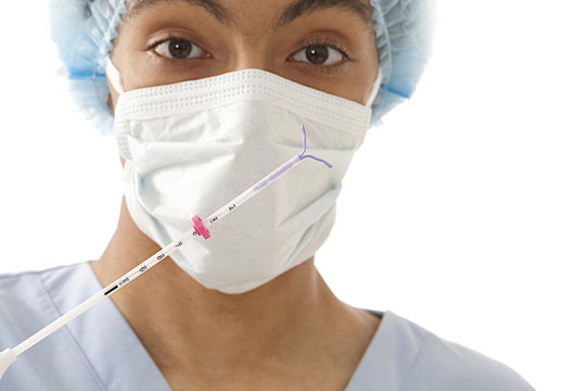 Young Mulatto  Doctor Ready To Use An IUD For Woman Contrception