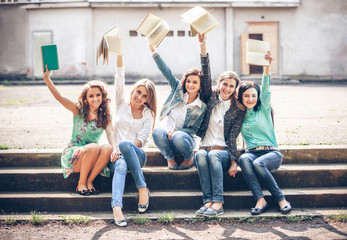 Fototapeta premium Group of students sitting with a books on street