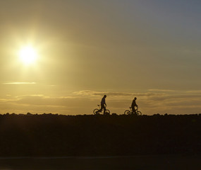 Fototapeta na wymiar Silhouettes of the boys and their bikes