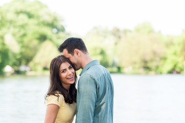 Obraz premium Young couple outdoors, near lake. hugging and havving a good time