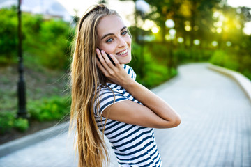 Naklejka premium A portrait of a smiling beautiful woman talking on the phone