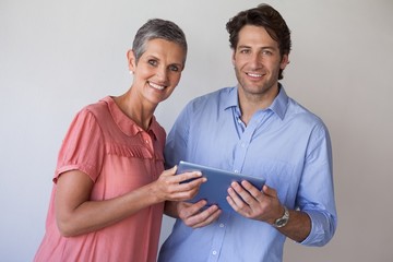 Casual smiling business team looking at tablet pc together