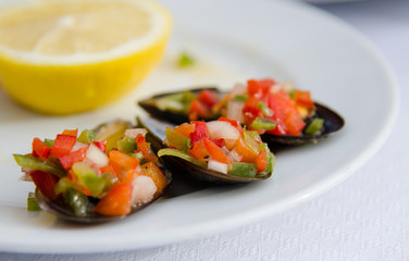 Tapas of chopped peppers, onions, and clams in shells