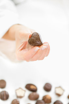 Women chef holding heart shaped Chocolate candy