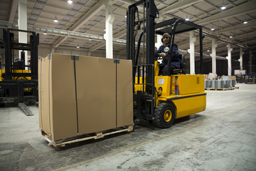 Forklift operator loading merchandise at warehouse