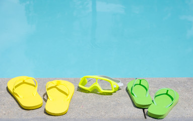 Color flip flops and water glasses by the pool