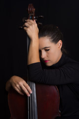 Beautiful brunette holding cello with selective light in black d © Alta Oosthuizen