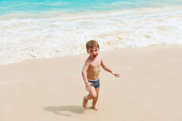 Two year old boy playing on beach