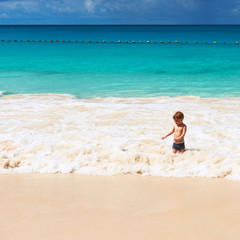 Two year old boy playing on beach