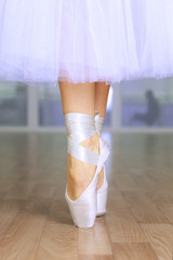 Ballerina legs in pointes in dancing hall © Africa Studio