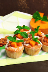 Tasty pumpkin muffins on wooden table