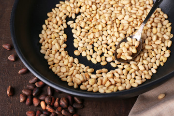 Cedar pine nuts on pan, on wooden table