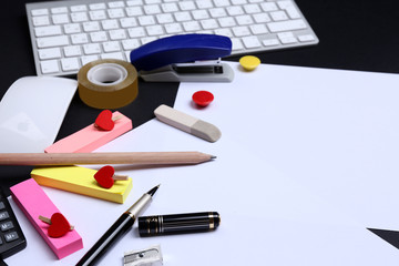 Office table with stationery accessories, keyboard and paper,