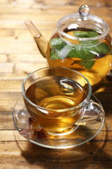 Composition of fresh mint tea in glass cup and teapot