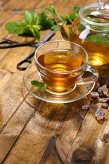 Composition of fresh mint tea in glass cup and teapot