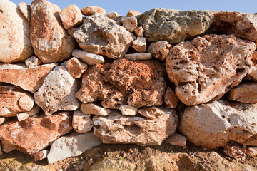 Muretto a secco con pietre rosse