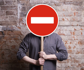 A man holds a sign forbidding face.