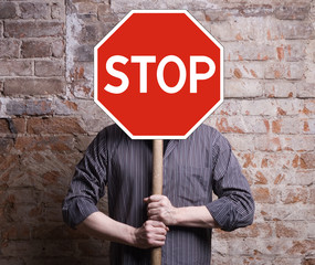 A man holds a sign forbidding face.