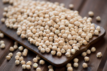 Raw chickpeas on a rustic wooden chopping board, studio shot
