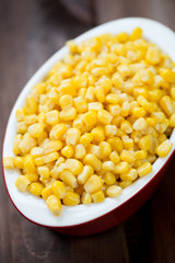Sweet corn kernels in a glass bowl, vertical shot, close-up