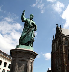 Fototapeta na wymiar Statue of Mr. Laurens Janszoon Coster and St, Bavo Church