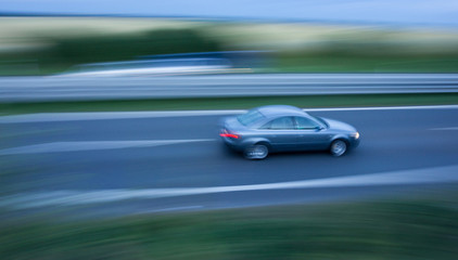 Obraz na płótnie Canvas Fast going car on the highway, motion blurred