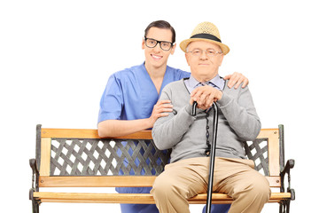 Medical professional and senior sitting on bench