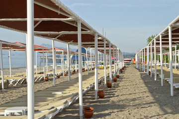The beach in the resort area with sun beds and umbrellas