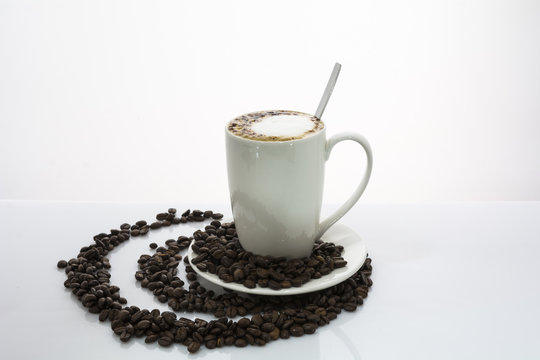 Kaffee mit Milchschaum auf Kaffeebohnenmuster
