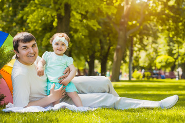 happy father and baby are playing in the park