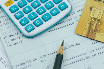 close up bank statement with calculator and credit card