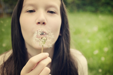 teen girl blowing on a dandelion toning