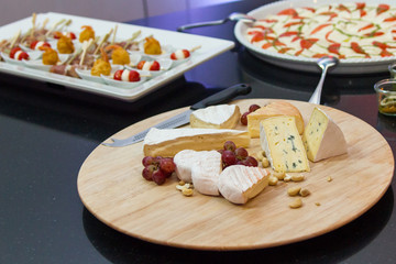 Käseplatte mit Häppchenteller im Hintergrund