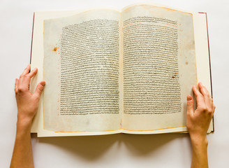 Hands turning pages of vintage book with handwritten text 