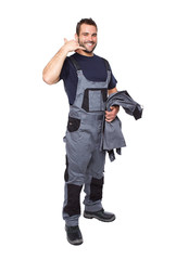 Smiling man in work clothes making a call me sign