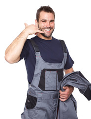 Smiling man in work clothes making a call me sign