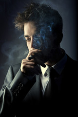 Young handsome stylish man smoking cigar