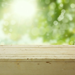 Fototapeta premium Nature background with empty wooden table over bokeh garden
