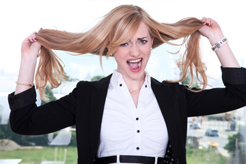 Blonde Geschäftsfrau zieht an Haare und schreit Porträt