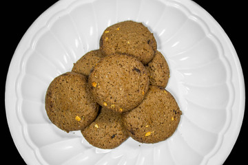 Cookie on plastic plate, isolated on black background