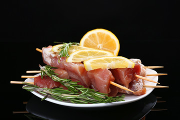 Raw pork kebab on black background