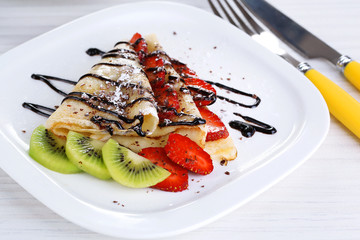 Delicious pancakes with strawberries and chocolate