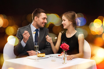 smiling couple eating dessert at restaurant