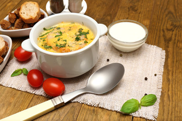 Tasty soup in saucepan on wooden table, close up