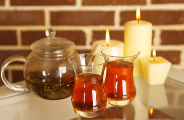 Composition with tea in cup and teapot and candles