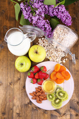 Healthy cereal with milk and fruits on wooden table