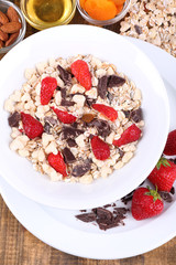Healthy cereal in bowl with strawberries and chocolate