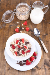 Healthy cereal in bowl with strawberries and chocolate