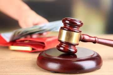 Gavel and hand holding money in wallet on wooden background