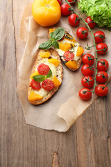 Tasty bruschetta with tomatoes, on old wooden table